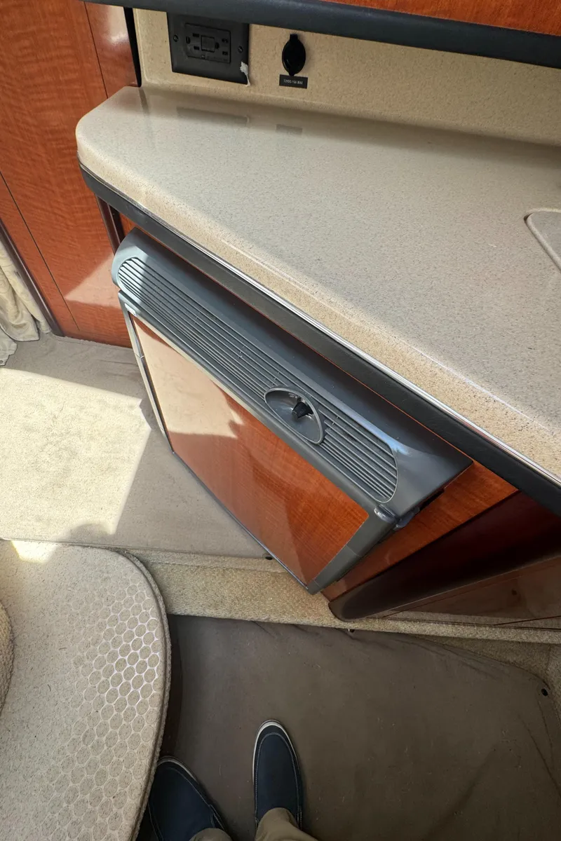 Slide: The Image of Interior of 2005 Sea Ray 260 Sundancer showing kitchenette with fridge and countertop. - 31