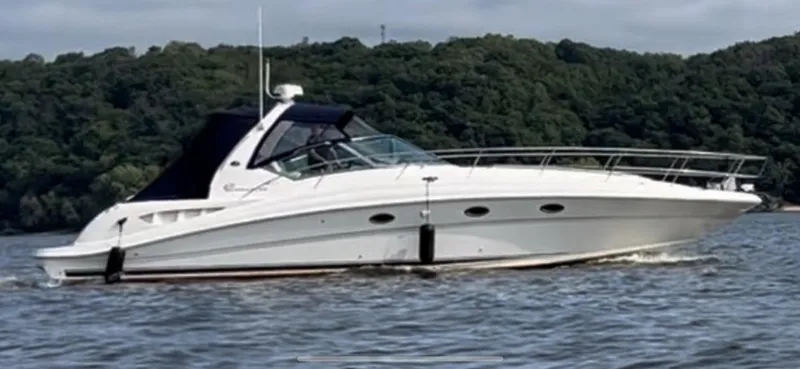 The Image of 2003 Sea Ray 420 Sundancer yacht cruising on a lake with forested background. - 0