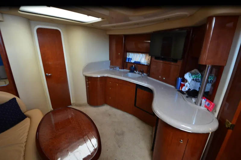Slide: The Image of Interior of 2003 Sea Ray 420 Sundancer yacht with modern kitchen and seating area. - 12