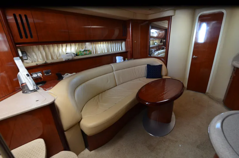 Slide: The Image of Interior of 2003 Sea Ray 420 Sundancer yacht with beige seating and wooden table. - 13