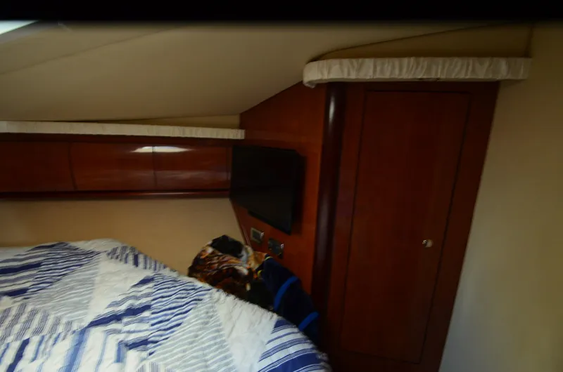 Slide: The Image of Interior cabin of 2003 Sea Ray 420 Sundancer with wood paneling and bed. - 16