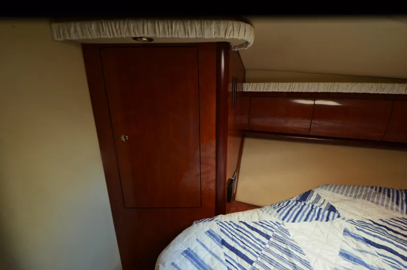 Slide: The Image of Interior cabin of 2003 Sea Ray 420 Sundancer with wood paneling and bed. - 17