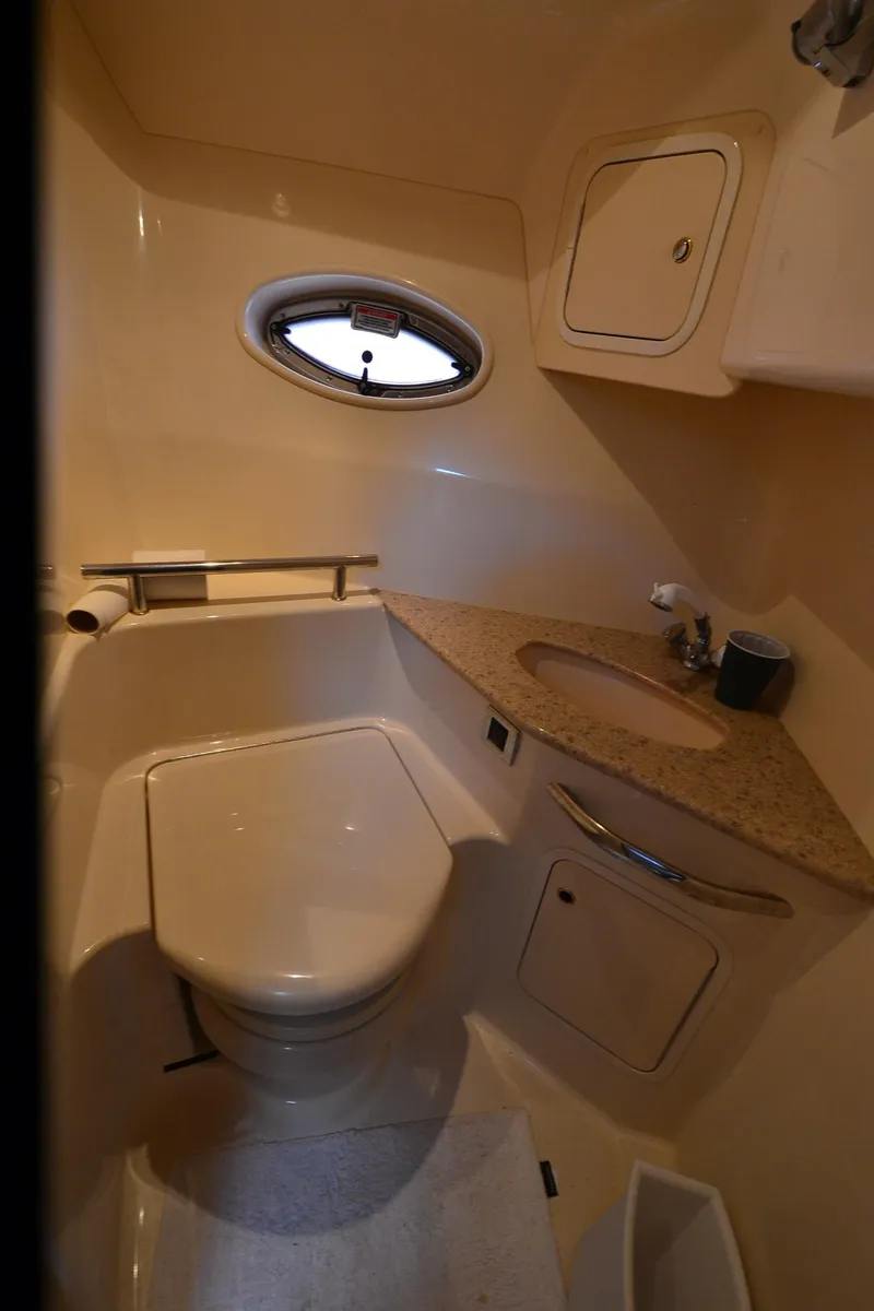 Slide: The Image of Bathroom interior of 2003 Sea Ray 420 Sundancer yacht with compact design and porthole window. - 23