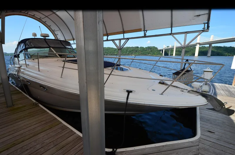 Slide: The Image of 2003 Sea Ray 420 Sundancer docked under a canopy by a river. - 3