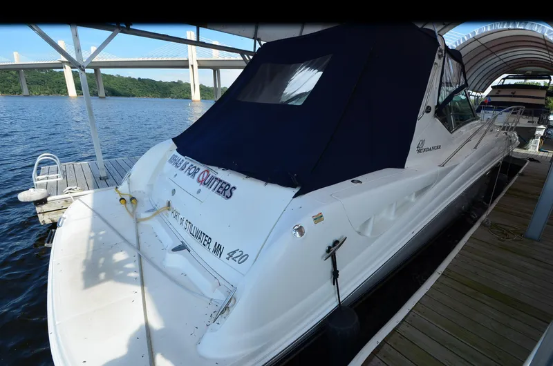 Slide: The Image of 2003 Sea Ray 420 Sundancer docked, covered, with scenic bridge and water view. - 4