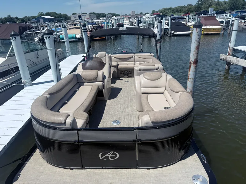 Slide: The Image of 2020 Avalon 2386 CR pontoon boat docked at marina with beige seating. - 2