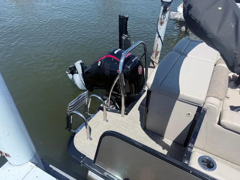 Slide: The Image of Avalon 2386 CR 2020 boat with outboard motor and seating, docked on calm water. - 6
