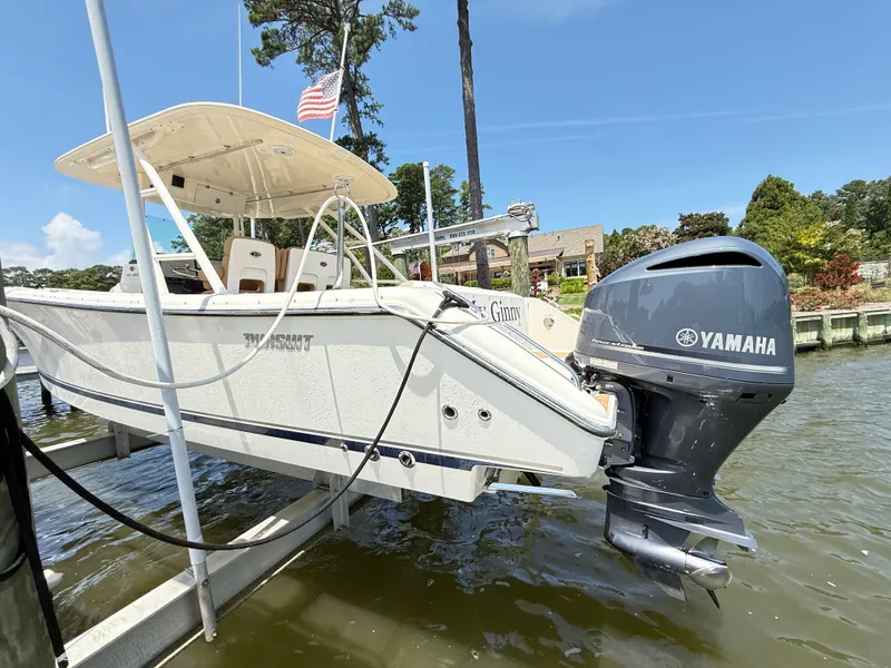 Slide: The Image of 2014 Pursuit ST 310 Sport boat with Yamaha engine on a lift by the water. - 10