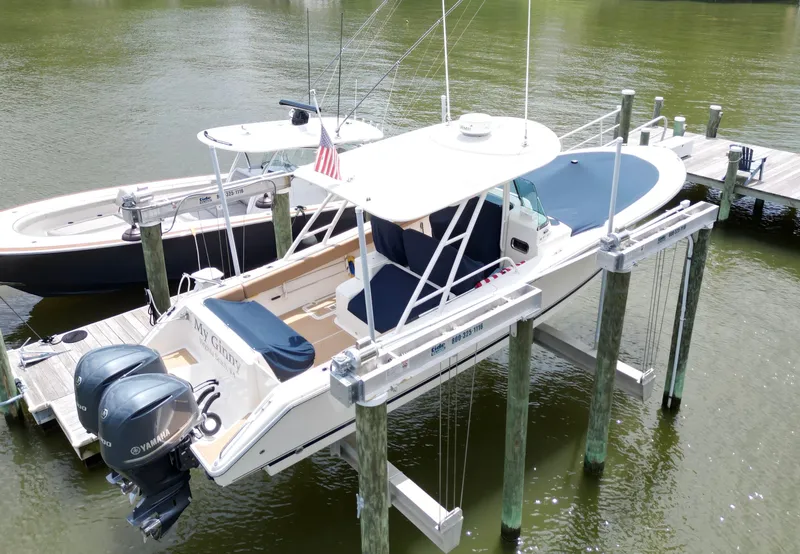 Slide: The Image of 2014 Pursuit ST 310 Sport boat docked with dual Yamaha engines, covered seating, and American flag. - 12