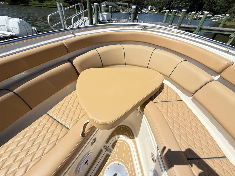 Slide: The Image of Luxurious seating area on a 2014 Pursuit ST 310 Sport boat, docked by the water. - 16