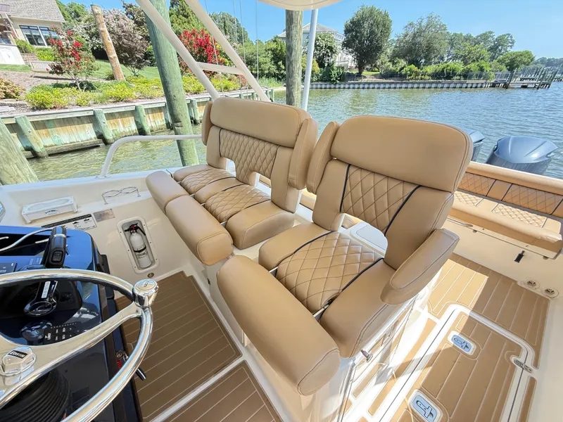 Slide: The Image of Luxurious seating on 2014 Pursuit ST 310 Sport boat, with scenic waterfront view. - 19