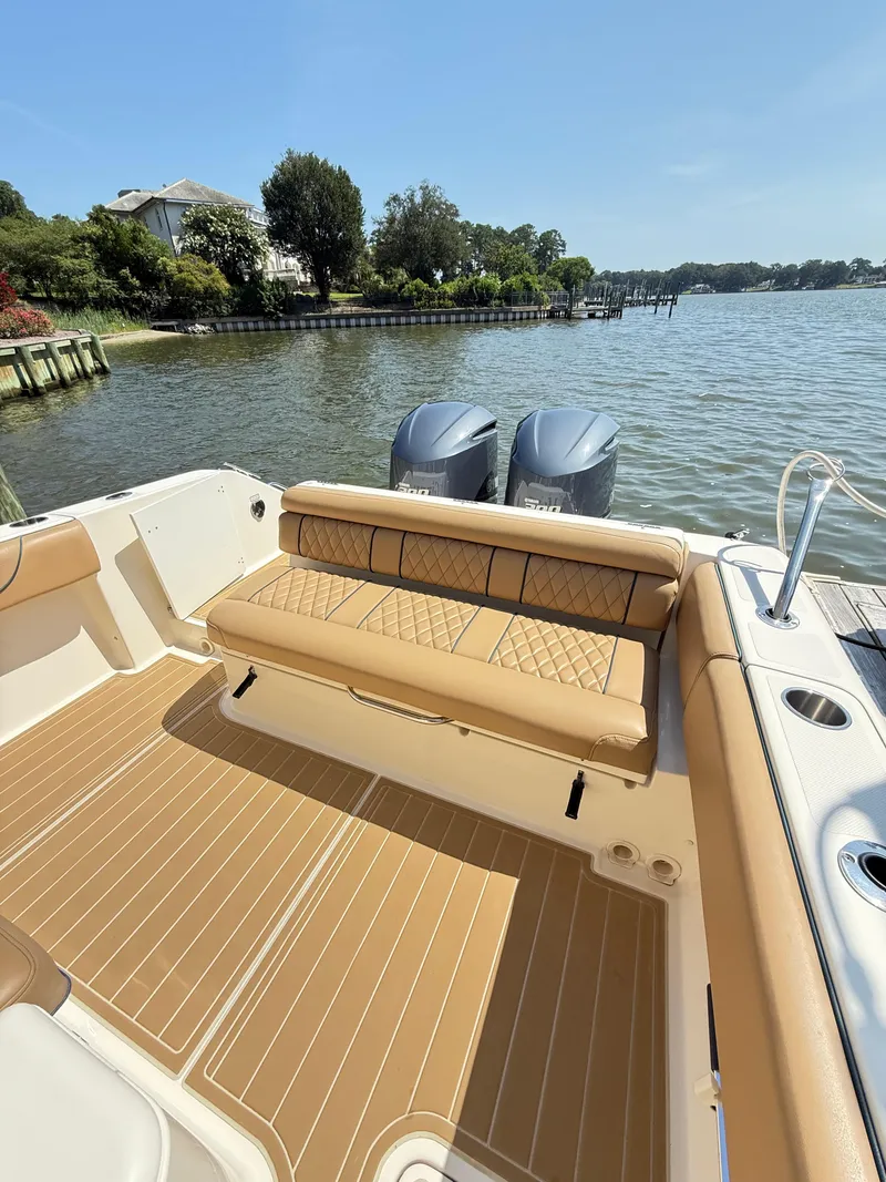 Slide: The Image of 2014 Pursuit ST 310 Sport boat with tan seating and dual engines on a sunny day. - 22