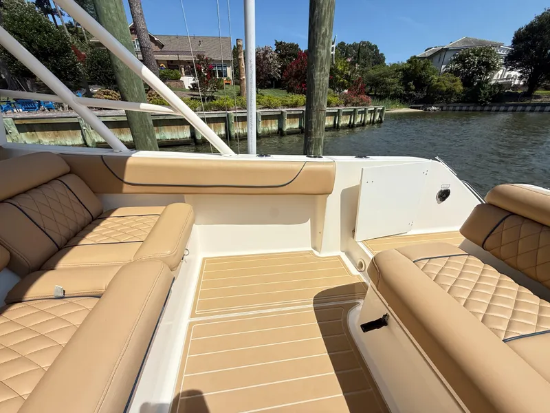 Slide: The Image of 2014 Pursuit ST 310 Sport boat interior with tan leather seating and waterfront view. - 23