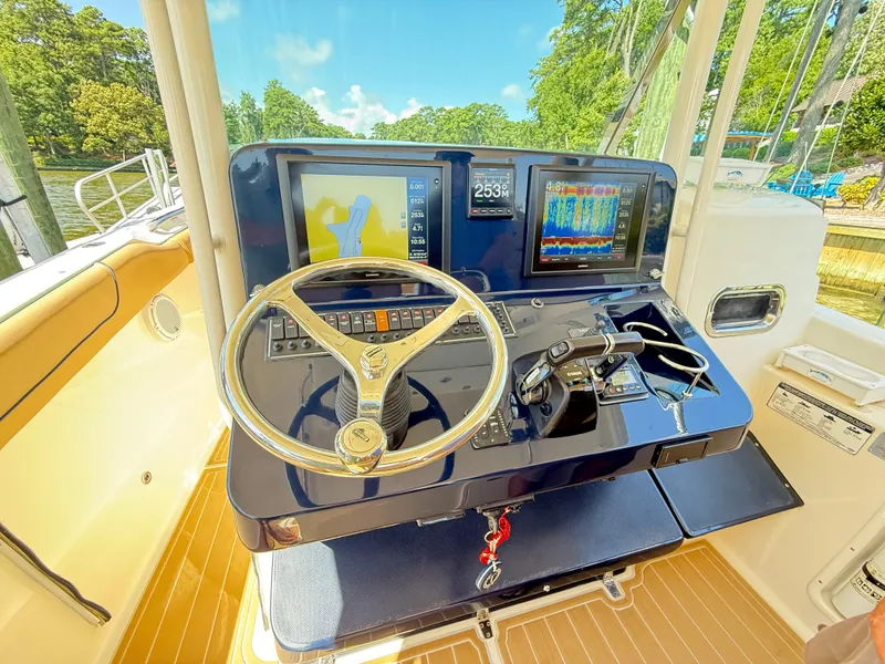 Slide: The Image of 2014 Pursuit ST 310 Sport boat dashboard with navigation screens and steering wheel. - 27