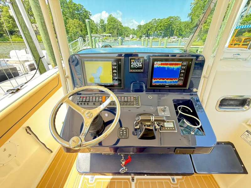 Slide: The Image of Control panel of a 2014 Pursuit ST 310 Sport boat with navigation screens and steering wheel. - 28