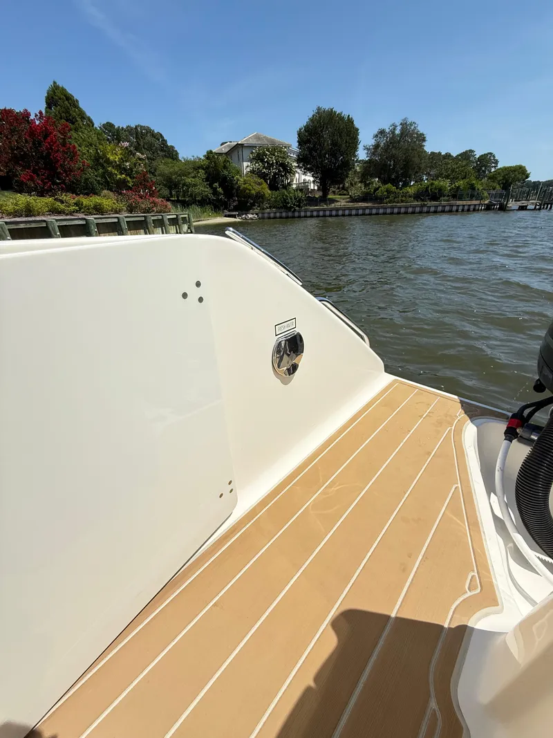 Slide: The Image of 2014 Pursuit ST 310 Sport boat deck by a scenic waterfront. - 35