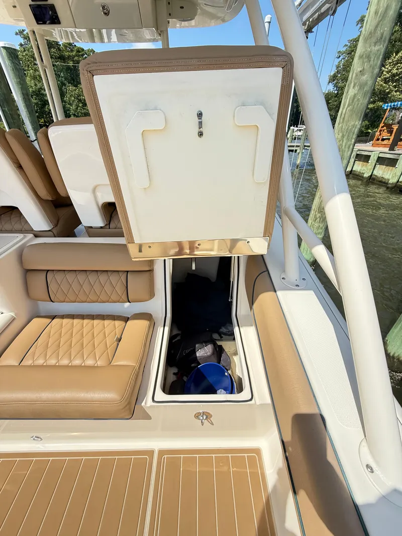 Slide: The Image of 2014 Pursuit ST 310 Sport boat interior with storage compartment open. - 38