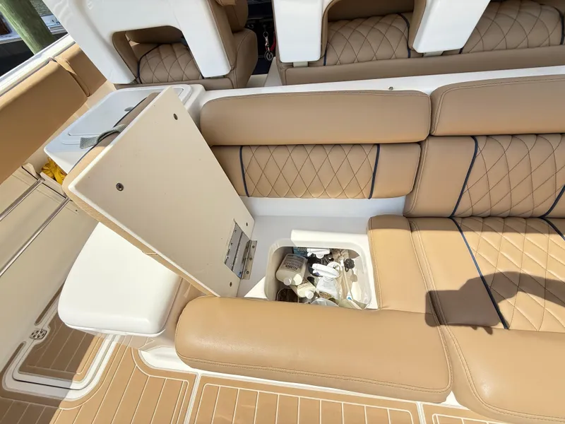 Slide: The Image of 2014 Pursuit ST 310 Sport boat interior with tan leather seats and storage compartment. - 39