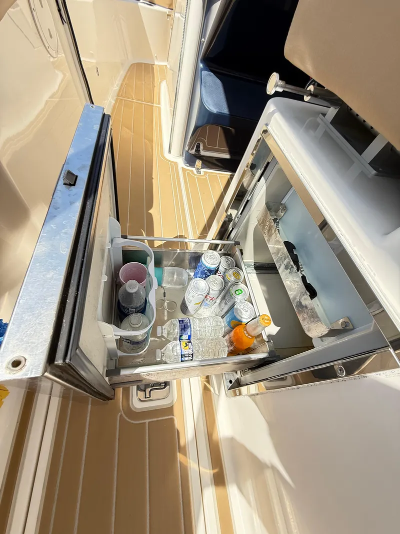 Slide: The Image of 2014 Pursuit ST 310 Sport boat with open cooler, stocked with drinks. - 44