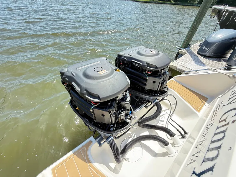 Slide: The Image of Twin outboard engines on a 2014 Pursuit ST 310 Sport boat docked by the water. - 47