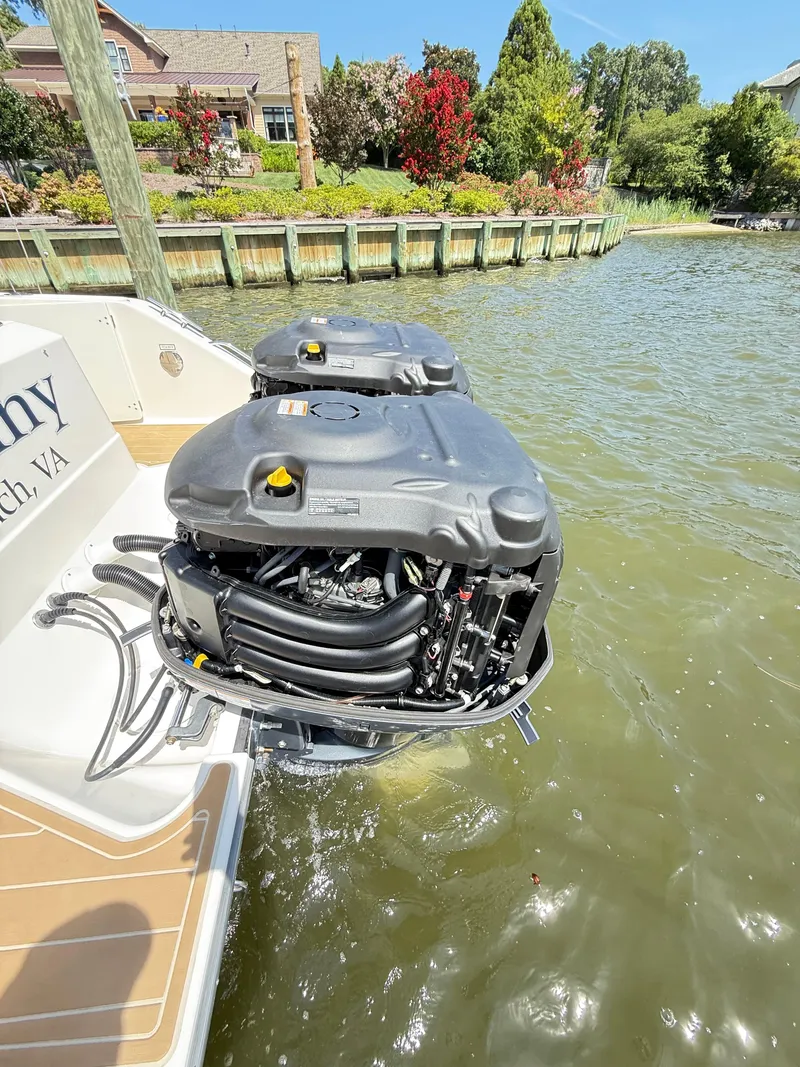 Slide: The Image of 2014 Pursuit ST 310 Sport boat with dual outboard engines on a sunny day. - 48