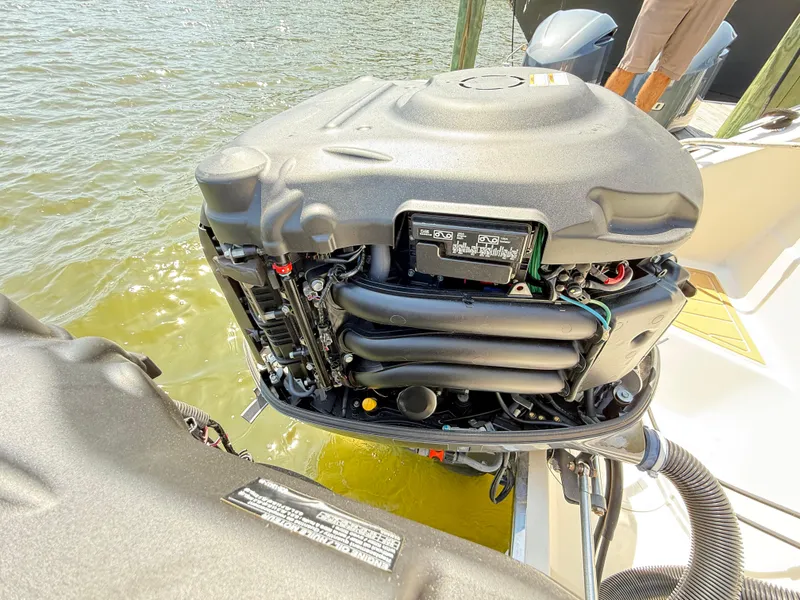 Slide: The Image of 2014 Pursuit ST 310 Sport outboard engine, open cover, docked by water. - 49