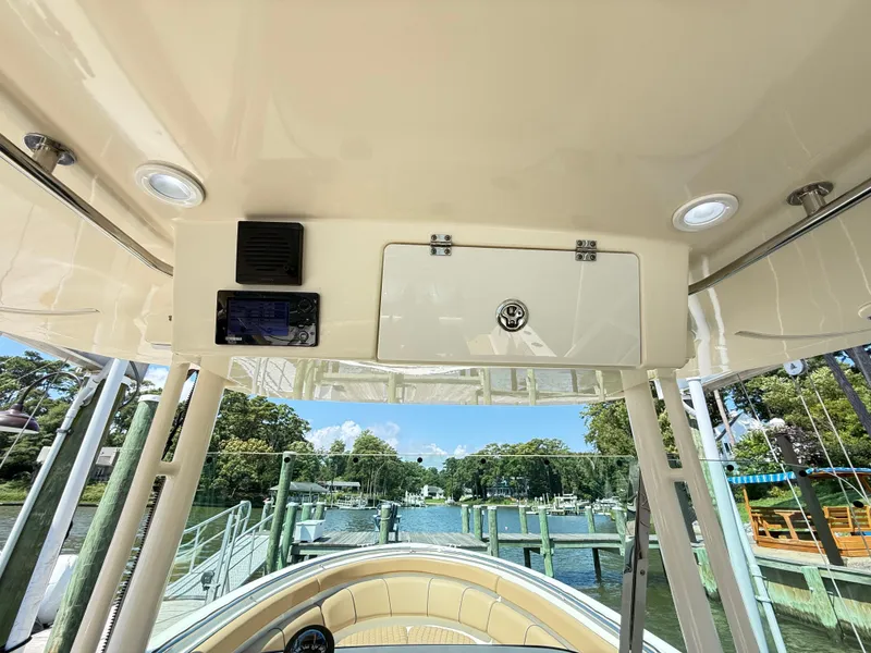 Slide: The Image of 2014 Pursuit ST 310 Sport boat interior with console and scenic marina view. - 50