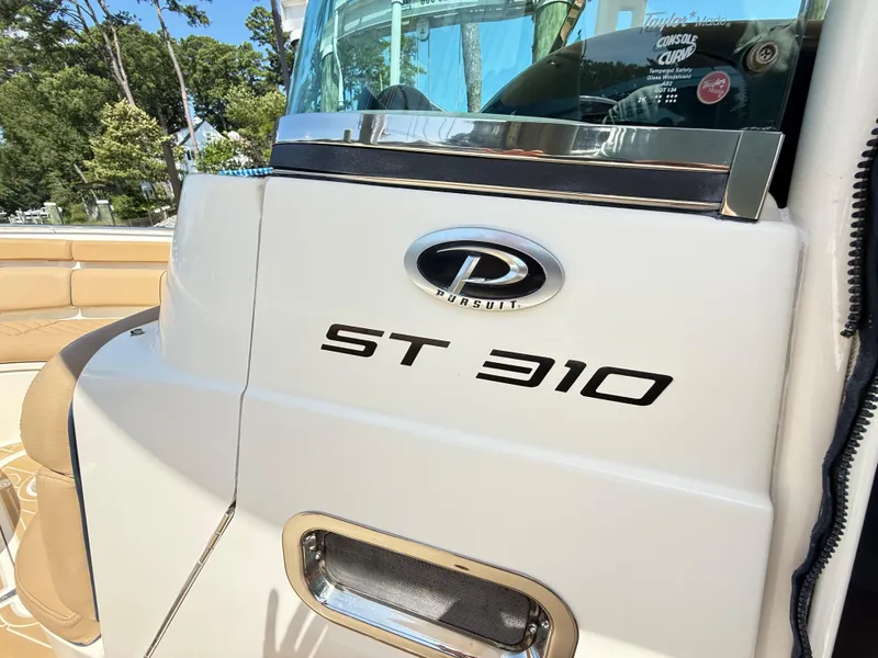 Slide: The Image of 2014 Pursuit ST 310 Sport boat, close-up of logo and model name. - 52