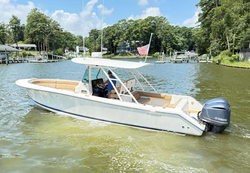 Slide: The Image of 2014 Pursuit ST 310 Sport boat on a calm lake with trees in the background. - 6
