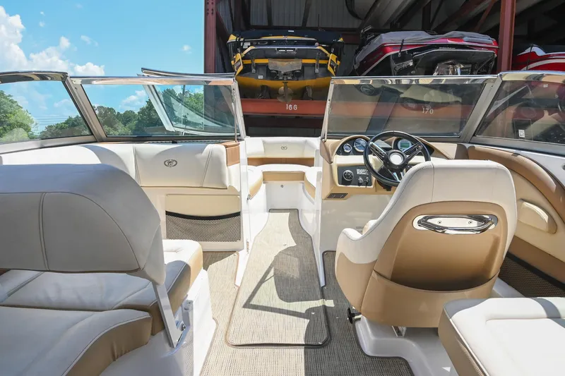 Slide: The Image of Interior of a 2015 Cobalt 220 boat with beige seating and steering wheel. - 20