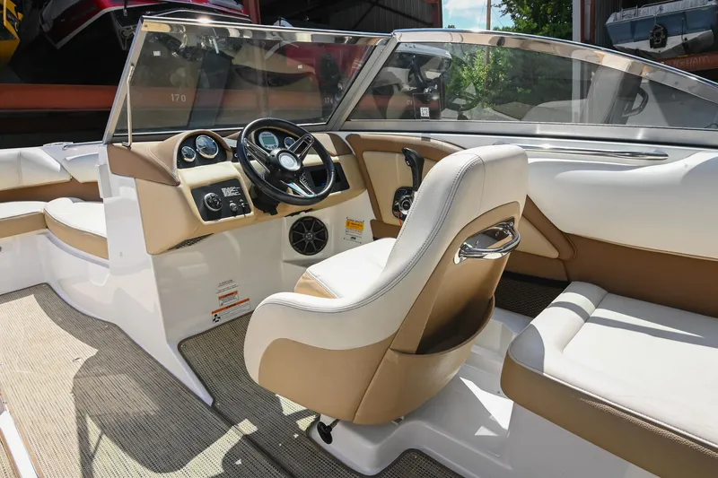 Slide: The Image of Interior of a 2015 Cobalt 220 boat featuring a sleek steering console and comfortable seating. - 25