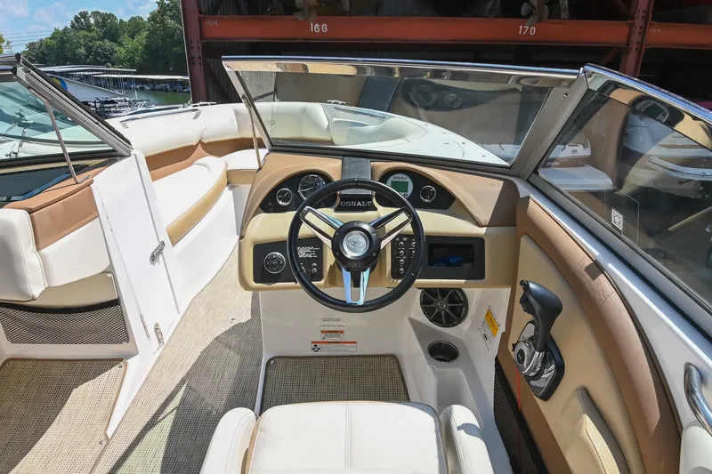 Slide: The Image of Interior of a 2015 Cobalt 220 boat, featuring steering wheel and controls. - 26