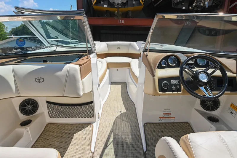 Slide: The Image of 2015 Cobalt 220 boat interior with beige and white seating, steering wheel, and dashboard. - 31