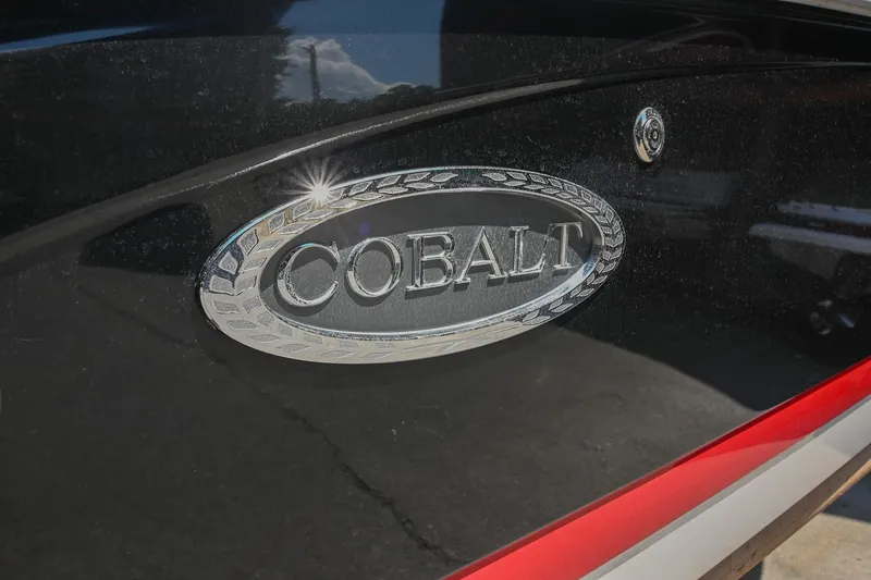 Slide: The Image of Cobalt 220 boat emblem on a sleek black surface, 2015 model. - 7