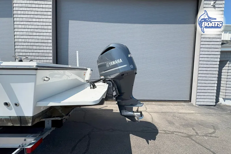 Slide: The Image of 2019 Parker 2320 Sport Cabin with Yamaha outboard motor, parked near a garage. - 31