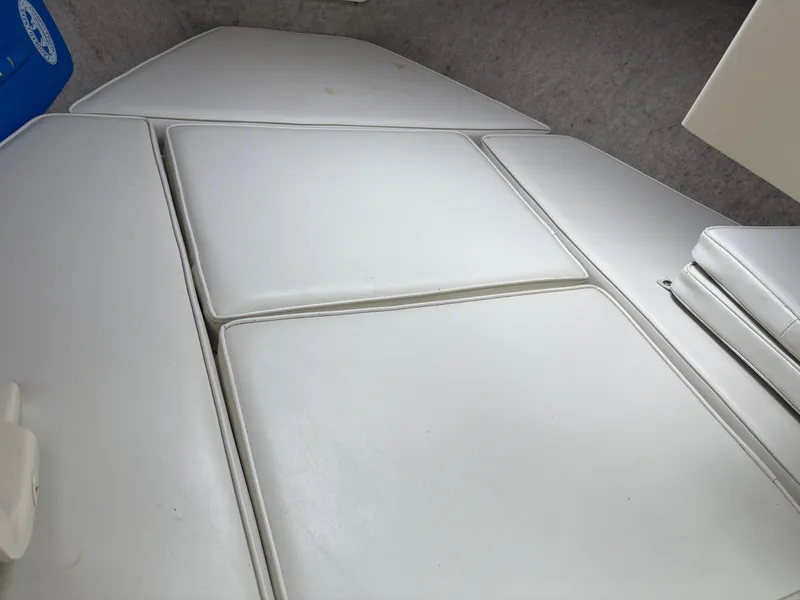 Slide: The Image of Interior cabin seating of 2012 Parker 2120 Sport Cabin boat, featuring white cushioned upholstery. - 15