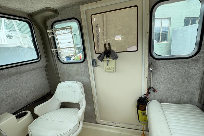 Slide: The Image of Interior of a 2012 Parker 2120 Sport Cabin boat with seating and windows. - 16