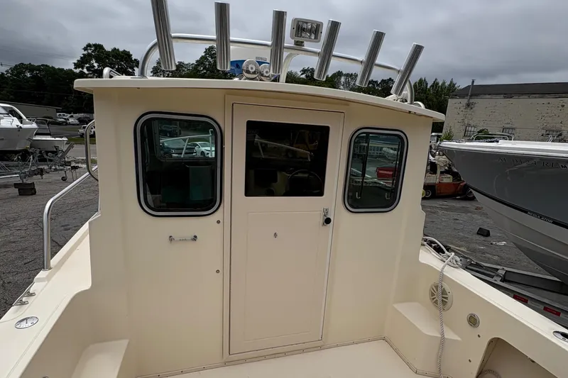 Slide: The Image of 2012 Parker 2120 Sport Cabin boat, rear view, docked with overcast sky. - 23