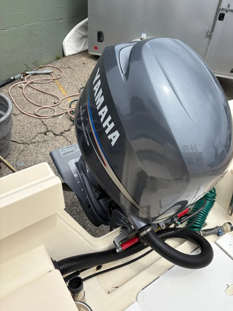 Slide: The Image of Yamaha outboard motor on a 2012 Parker 2120 Sport Cabin boat, parked outdoors. - 27