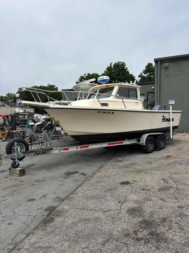 Slide: The Image of 2012 Parker 2120 Sport Cabin boat on trailer in outdoor setting. - 3