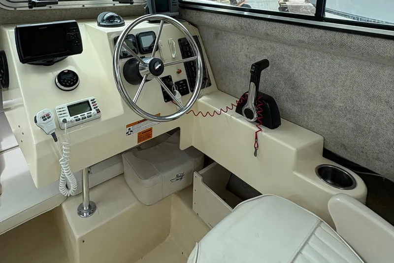 Slide: The Image of Interior of 2012 Parker 2120 Sport Cabin boat with steering wheel and control panel. - 7