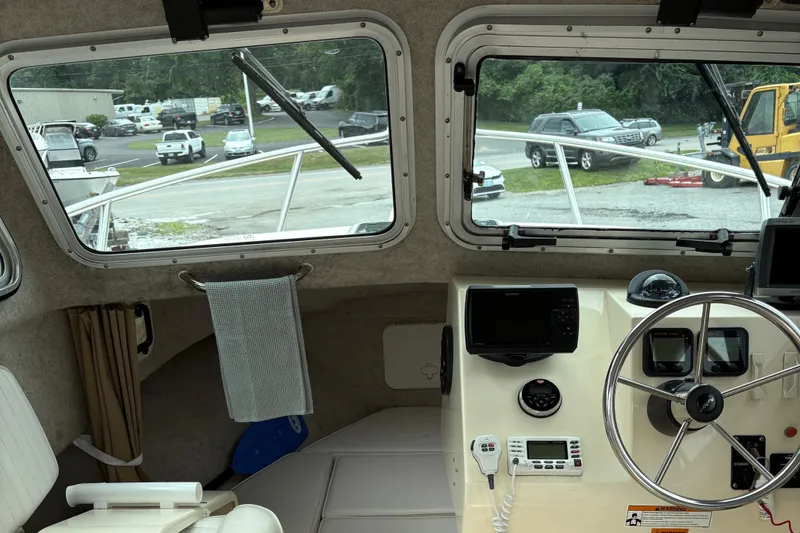 Slide: The Image of Interior view of a 2012 Parker 2120 Sport Cabin boat's helm with steering wheel and navigation equipment. - 8