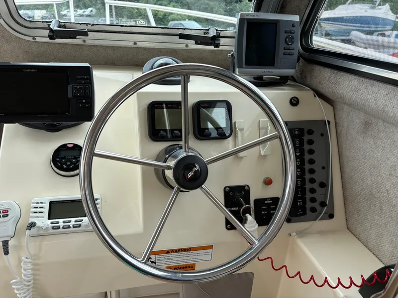Slide: The Image of Steering wheel and dashboard of a 2012 Parker 2120 Sport Cabin boat with navigation equipment. - 9