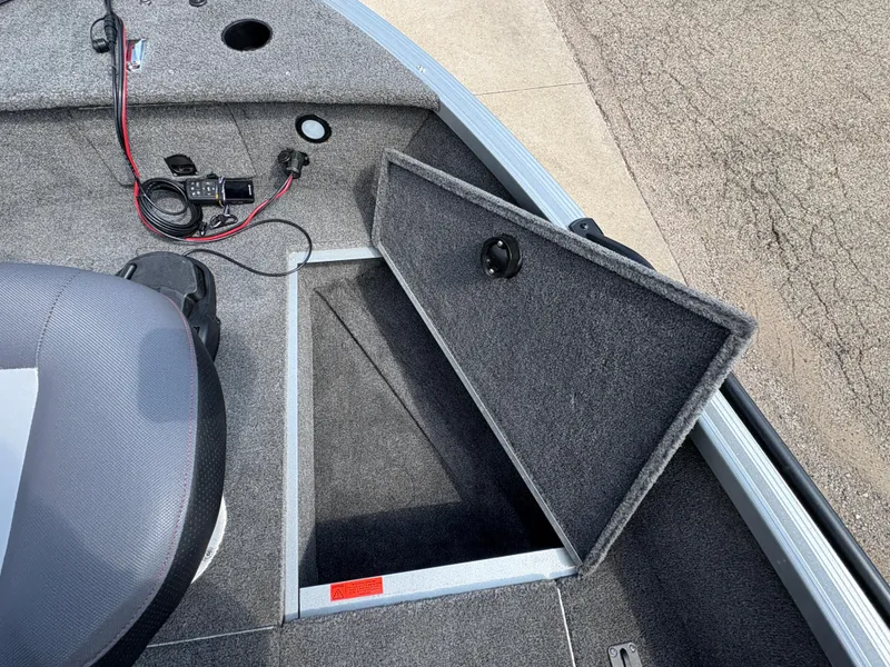 Slide: The Image of 2018 Alumacraft Voyageur 175 Sport boat interior with open storage compartment. - 13