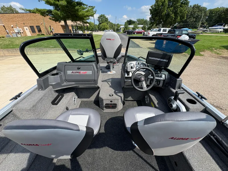 Slide: The Image of 2018 Alumacraft Voyageur 175 Sport boat interior with steering wheel and seating. - 18