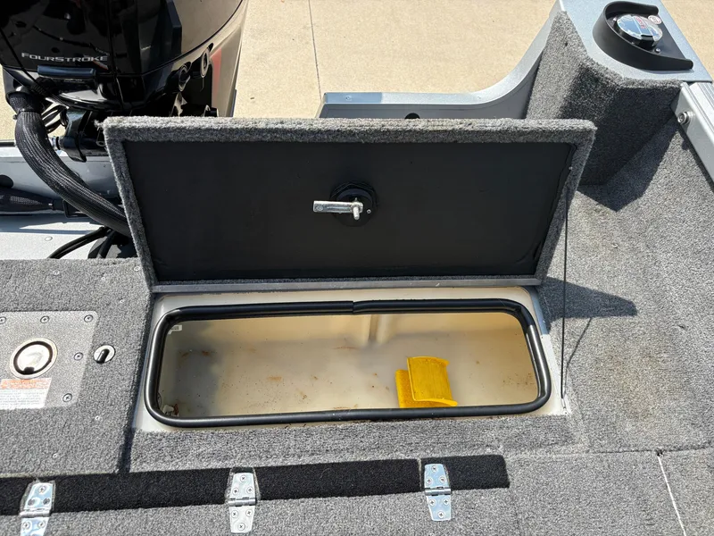 Slide: The Image of Open storage compartment on 2018 Alumacraft Voyageur 175 Sport boat, with yellow item inside. - 29