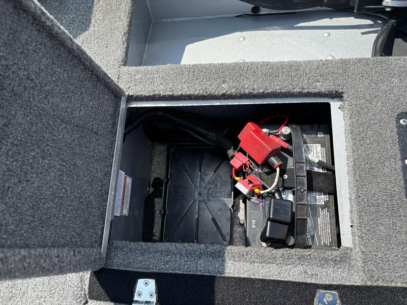 Slide: The Image of 2018 Alumacraft Voyageur 175 Sport battery compartment with wiring and connections. - 30
