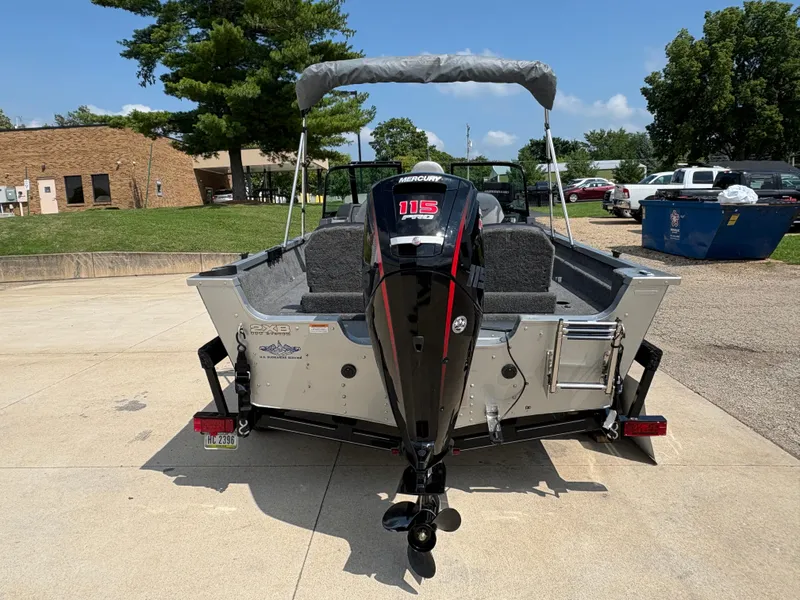 Slide: The Image of 2018 Alumacraft Voyageur 175 Sport boat with Mercury 115 outboard motor, parked outdoors. - 4