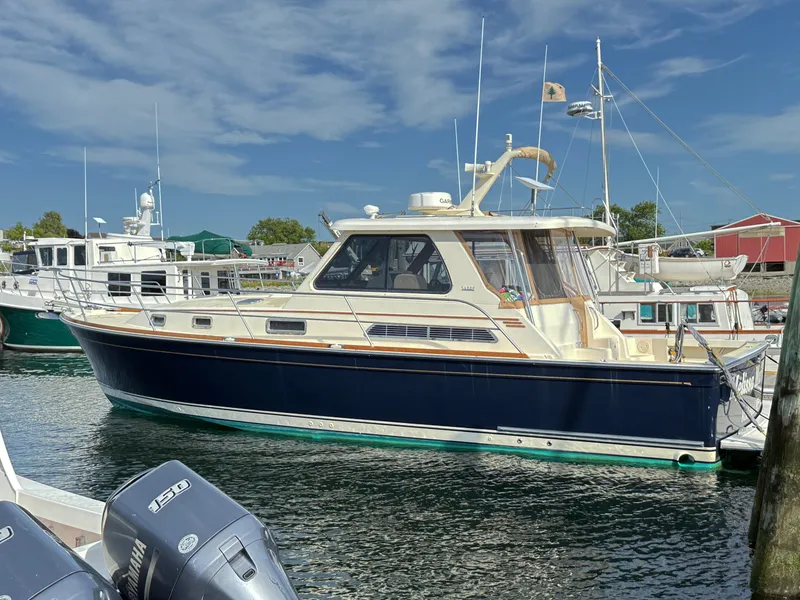 The Image of 2006 Sabre 38 Hardtop Express yacht docked in marina under clear blue sky. - 0