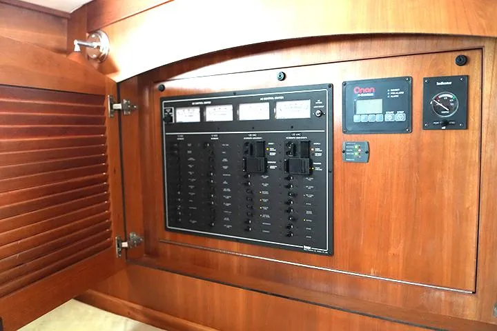 Slide: The Image of Electrical control panel inside 2006 Sabre 38 Hardtop Express yacht, featuring wooden cabinetry. - 11